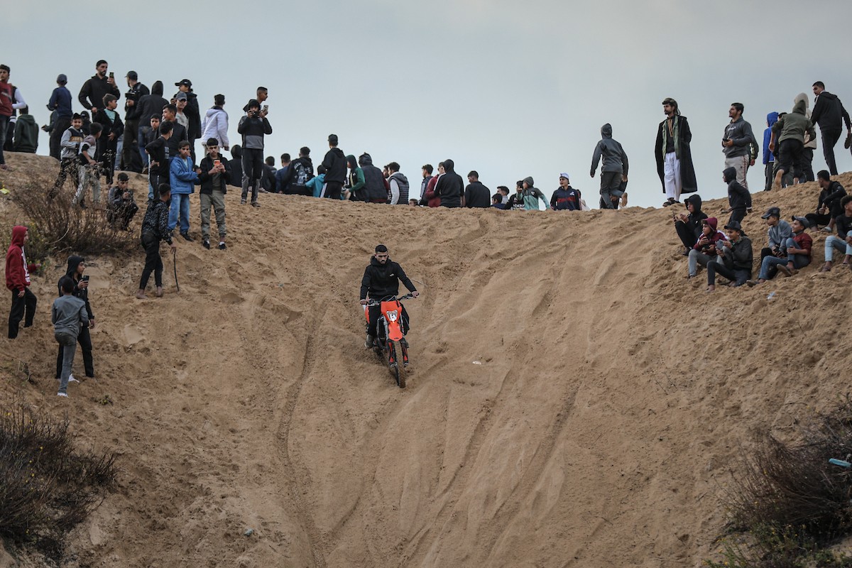 شبان فلسطينيون يركبون الدراجات النارية على الكثبان الرملية في بلدة الزهراء، بعد انقطاع دام عامين عن هذه الرياضة بسبب الحرب واحتلال الجيش الإسرائيلي للمنطقة المعروفة سابقا بمحور
