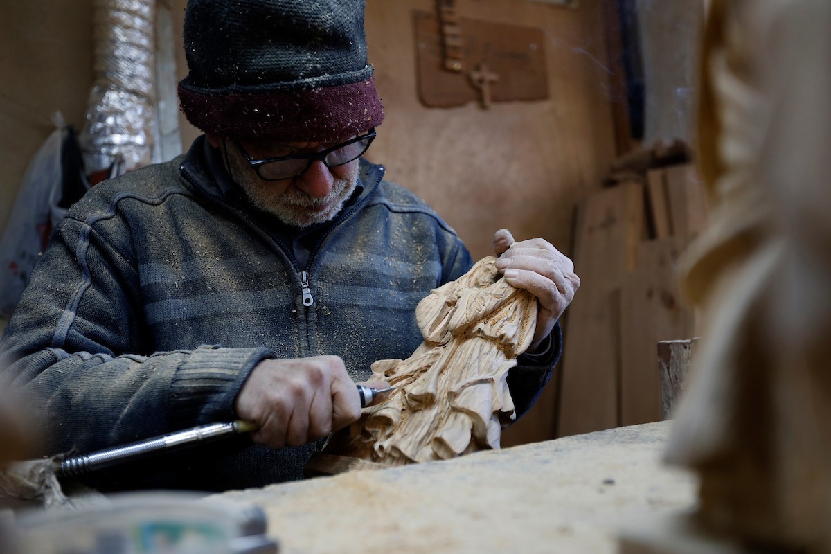 نحت خشب الزيتون في بيت لحم لصنع قطع فنية وهدايا متنوعة، تشمل منحوتات دينية وزخارف تقليدية وتذكارات، استعدادًا لعيد الميلاد، 18 ديسمبر/كانون الأول 2025 تصوير: مأمون وزواز/ (apa)