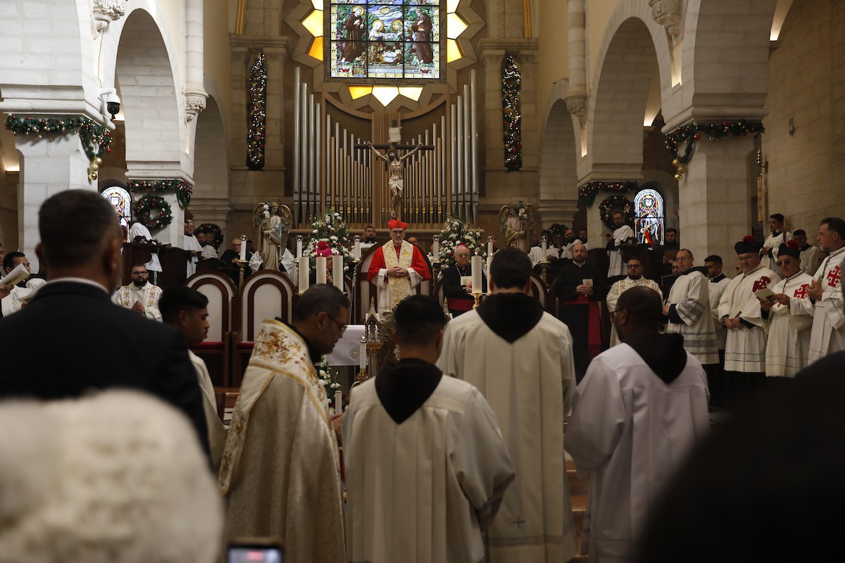 البطريرك اللاتيني للقدس، الكاردينال الإيطالي بييرباتيستا بيتسابالا يستقبل الحجاج والسياح لدى وصوله لترؤس قداس منتصف الليل في كنيسة المهد بمدينة بيت لحم، 24 ديسمبر/كانون الأول 2025،  (صور: مأمون وزواز/ apa)