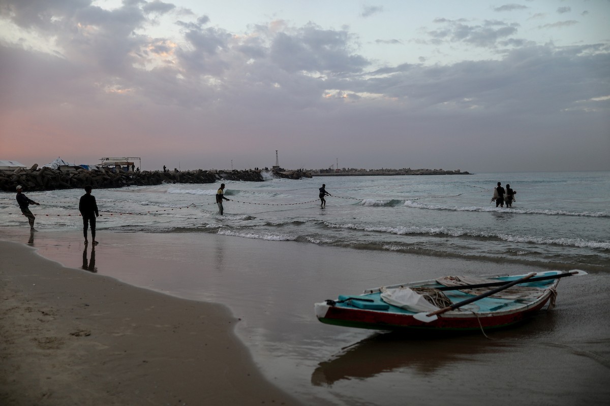 يقضي فلسطينيون نازحون وقتًا على الشاطئ مقابل خيامهم الممتدة على طول ميناء غزة، في غزة، 5 ديسمبر/كانون الأول 2025. تصوير: عمر أشتوي