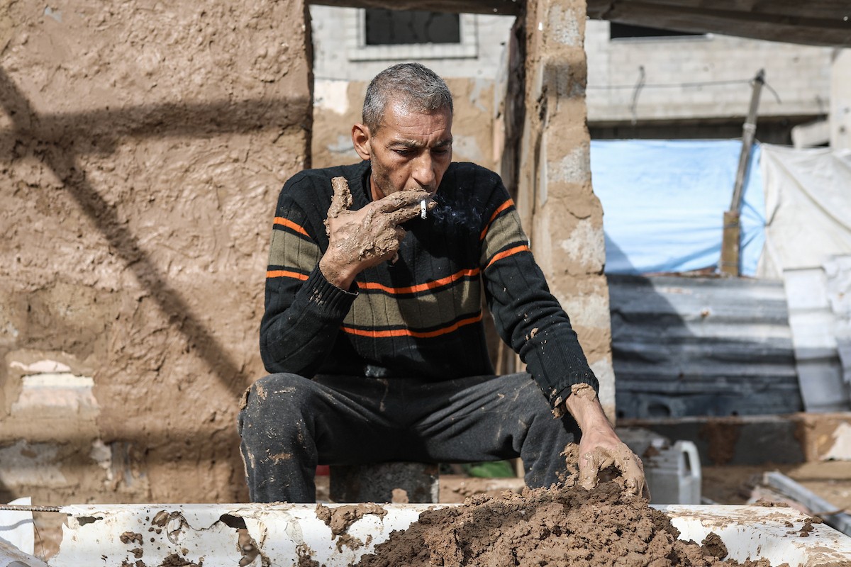 الفلسطيني أحمد المبحوح، مريض سرطان، يبني منزلاً طينياً بيديه في مخيم البريج للاجئين وسط قطاع غزة، 15 ديسمبر/كانون الأول 2025. عدسة: رمزي أبو عامر