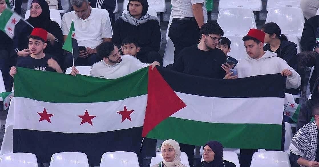 رفع العلمين الفلسطيني والسوري معًا، خلال المباراة.jpg