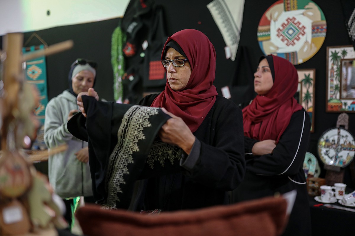 فلسطينيون يحضرون معرضًا يعرض منتجات يدوية من صنع مجموعة من الحرفيين الصم في مدينة غزة