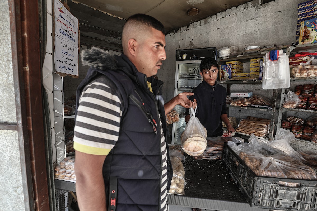 عمال فلسطينيون يعيدون تشغيل أحد أقدم المخابز في مخيم النصيرات للاجئين بعد إغلاقه لمدة عامين بسبب الحرب (7).jpg