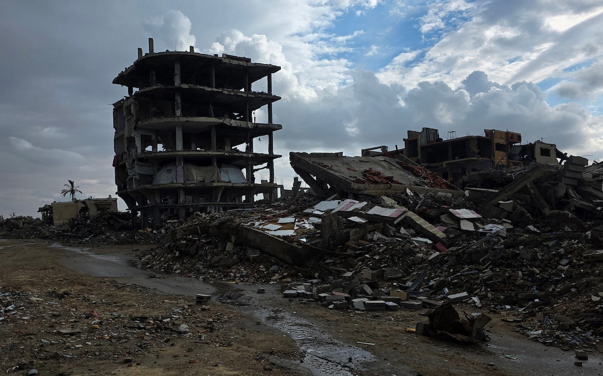 عائلة فلسطينية تحتمي من برد الشتاء القارس في خيمة نصبتها فوق منزلها المدمر قرب الخط الأصفر في خان يونس، جنوب قطاع غزة، ١٧ ديسمبر/كانون الأول ٢٠٢٥. تصوير: طارق محمد/وكالة الأنباء الفلسطينية (APA )