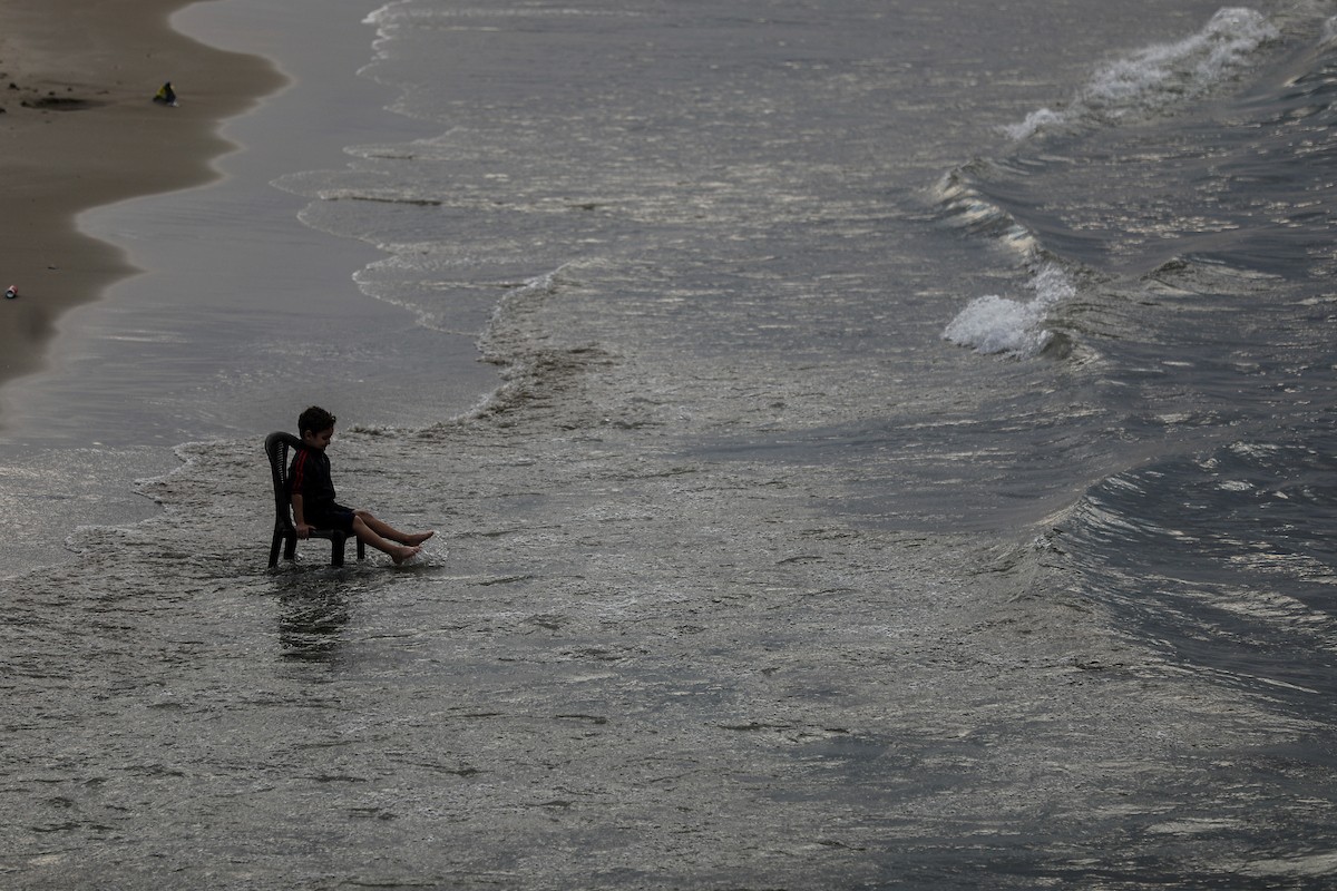يقضي فلسطينيون نازحون وقتًا على الشاطئ مقابل خيامهم الممتدة على طول ميناء غزة، في غزة، 5 ديسمبر/كانون الأول 2025. تصوير: عمر أشتوي
