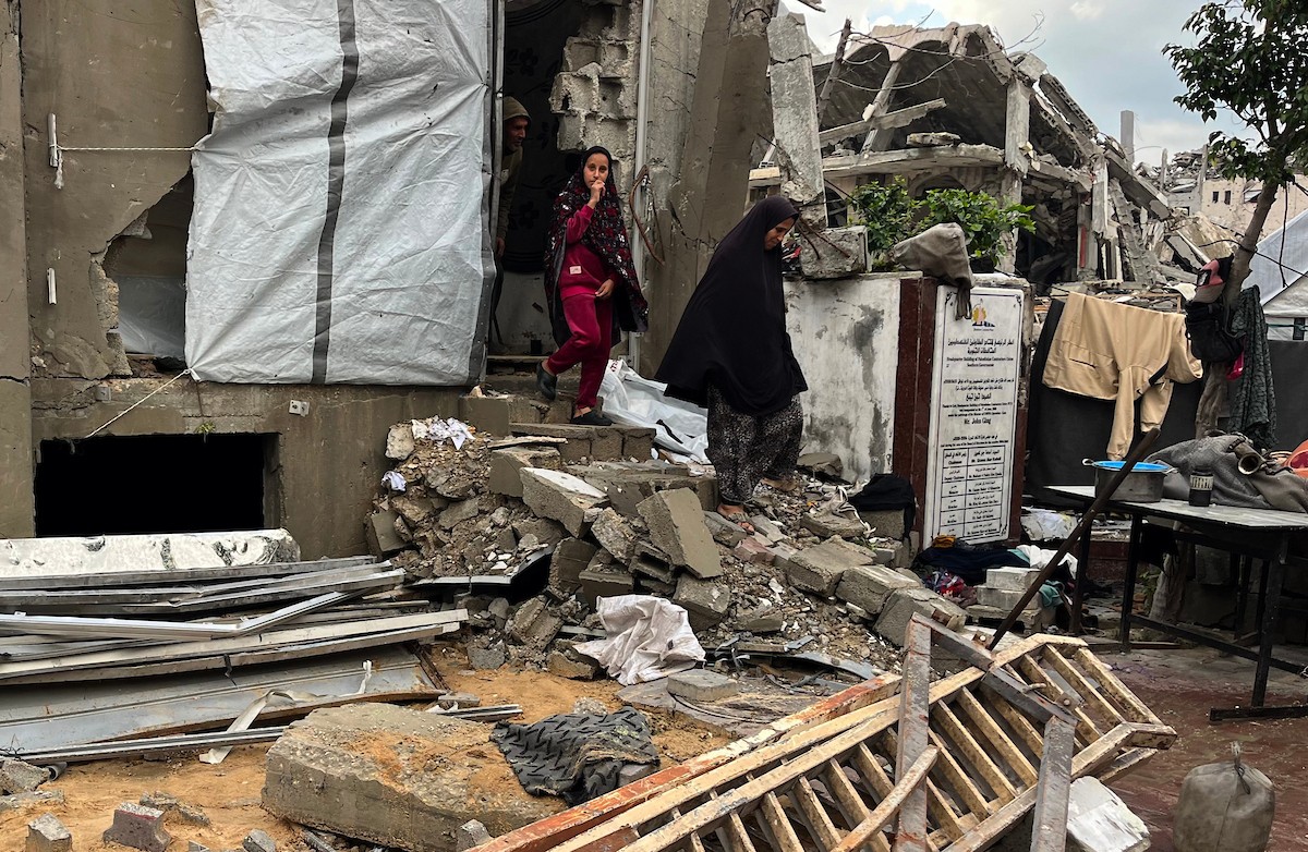 يعيش أشرف وشادية السرساوي مع أحفادهما العشرة داخل خيمة مؤقتة نُصبت في مبنى غير آمن إنشائياً غرب مدينة غزة، وسط تدهور الأوضاع الإنسانية.18 ديسمبر/كانون الأول 2025. صورة: مطر الزاق