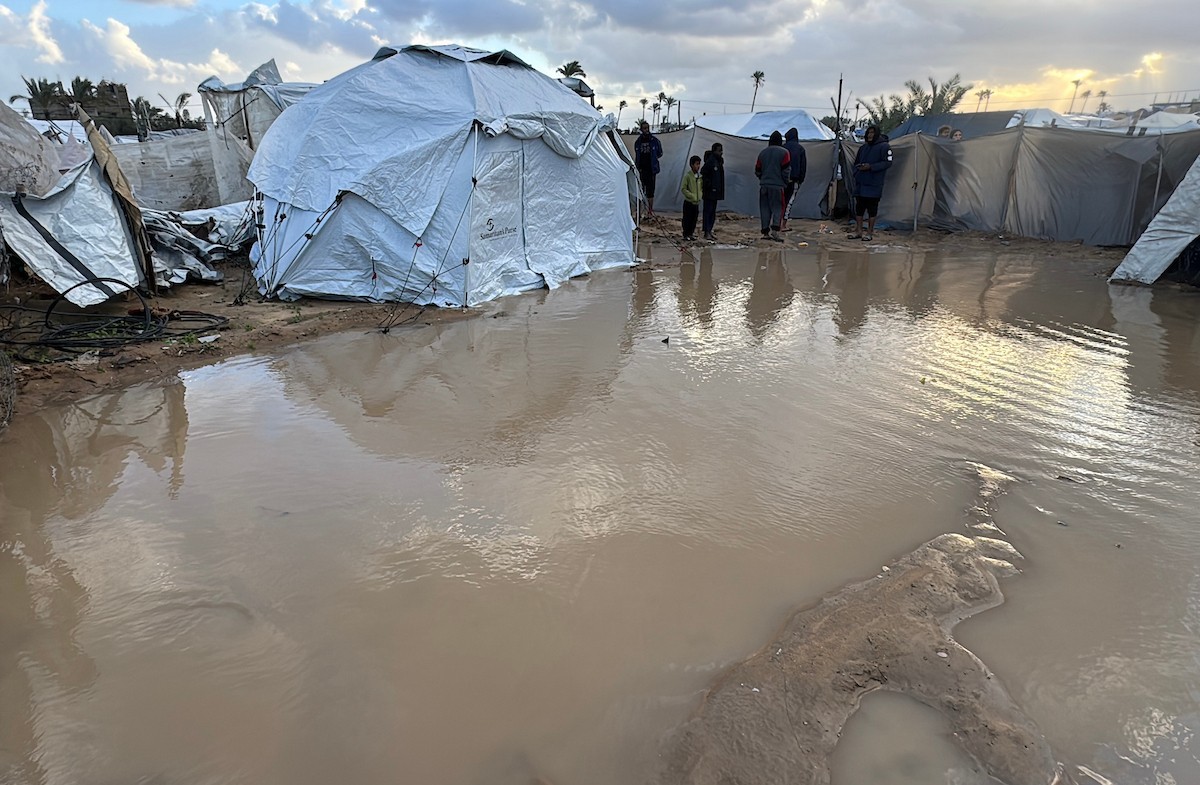 يُكافح الفلسطينيون النازحون، المقيمون في خيام مؤقتة، من أجل البقاء في ظل ظروف قاسية، حيث تجتاح الأمطار والعواصف الشديدة دير البلح، وسط قطاع غزة، في 28 ديسمبركانون الأول 2025. صورة أحمد إبراهيم(APA)
