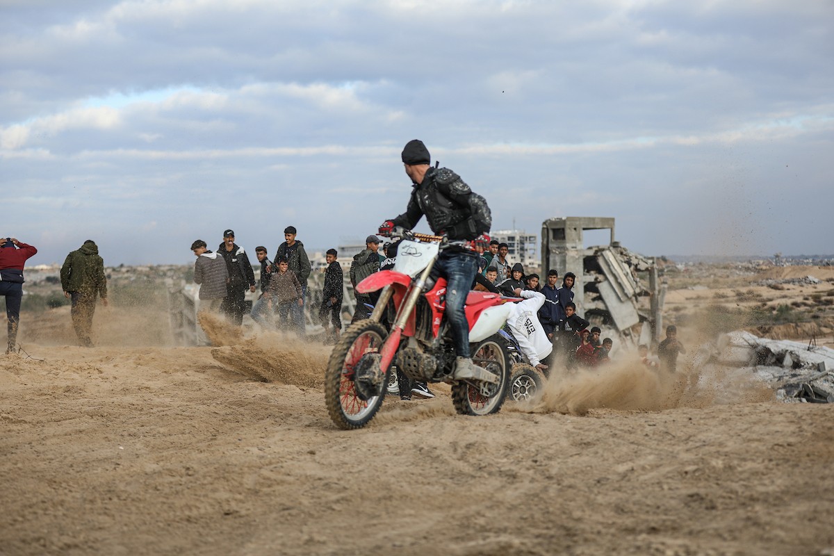 شبان فلسطينيون يركبون الدراجات النارية على الكثبان الرملية في بلدة الزهراء، بعد انقطاع دام عامين عن هذه الرياضة بسبب الحرب واحتلال الجيش الإسرائيلي للمنطقة المعروفة سابقا بمحور