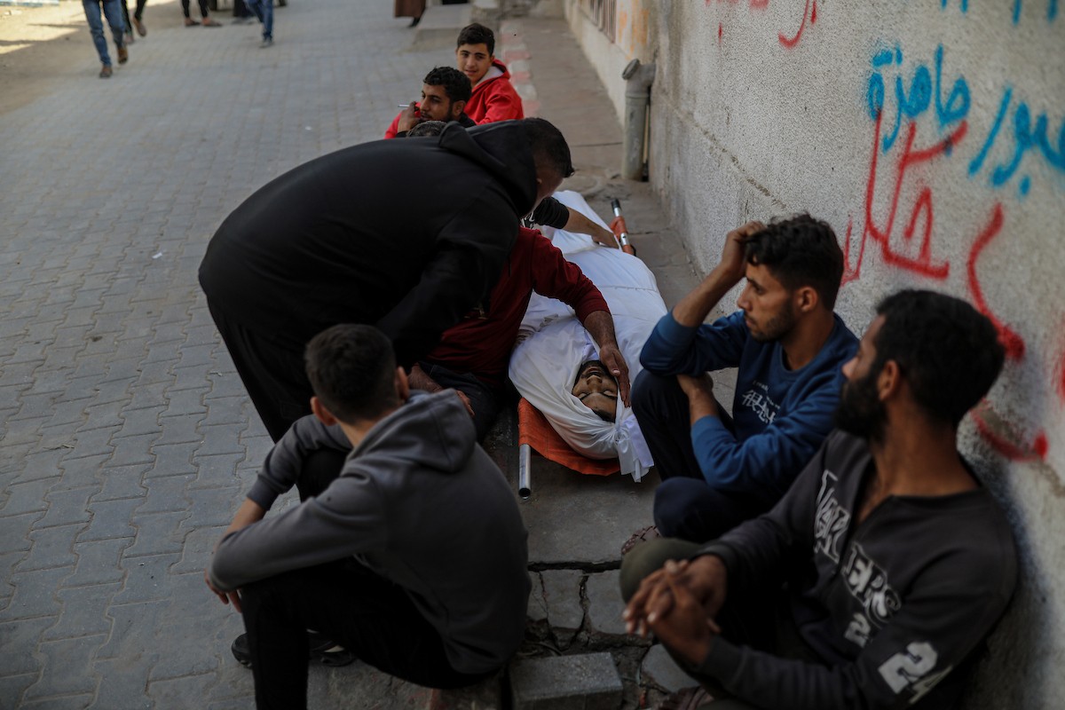 فلسطينيون ينعون ويحملون جثامين عدد من القتلى في غارة إسرائيلية على بيت لاهيا، بينهم أحد عناصر الدفاع المدني، خلال جنازة في مستشفى الشفاء بمدينة غزة