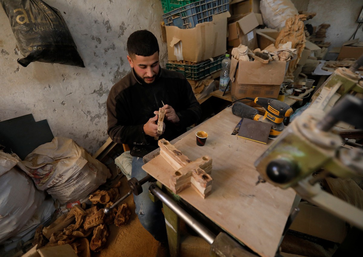 نحت خشب الزيتون في بيت لحم لصنع قطع فنية وهدايا متنوعة، تشمل منحوتات دينية وزخارف تقليدية وتذكارات، استعدادًا لعيد الميلاد، 18 ديسمبر/كانون الأول 2025 تصوير: مأمون وزواز/ (apa)