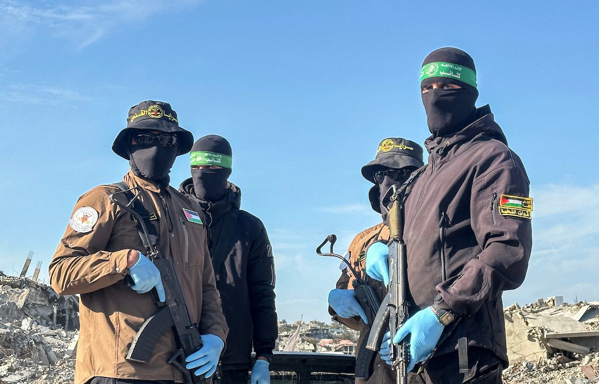 مسلحون من حماس والجهاد الإسلامي في فلسطين يسلمون لأفراد الصليب الأحمر جثة استعادوها من بيت لاهيا قبل تسليمها لإسرائيل لتحديد ما إذا كانت تعود لأحد الرهائن، شمال قطاع غزة، 3 ديسمبر/كانون الأول 2025