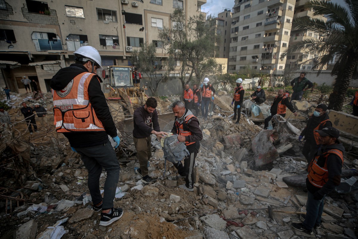 عمال الدفاع المدني الفلسطيني يبحثون عن جثث في مبنى منهار يعود لعائلة سالم، استُهدف بغارات إسرائيلية في بداية الحرب، في شارع الجلاء بمدينة غزة، يوم الاثنين 15 ديسمبر/كانون الأول 2025. صورة: عمر أشتوي