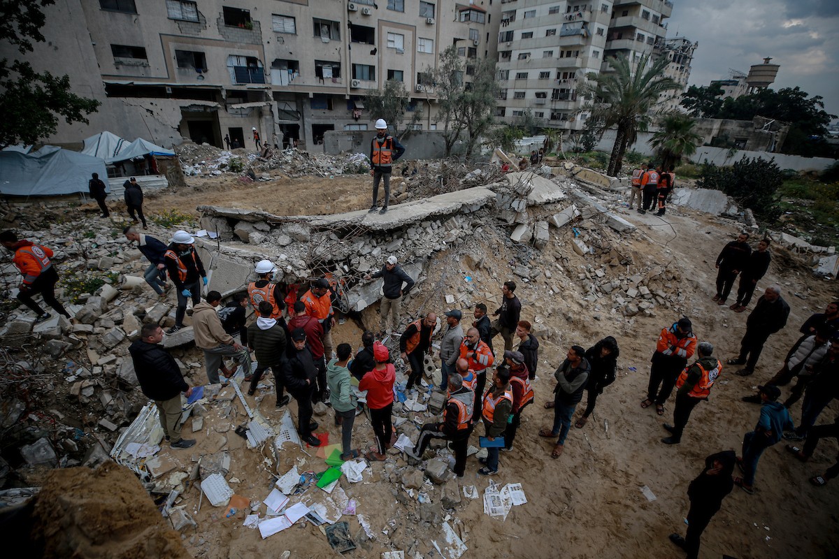 عمال الدفاع المدني الفلسطيني يبحثون عن جثث في مبنى منهار يعود لعائلة سالم، استُهدف بغارات إسرائيلية في بداية الحرب، في شارع الجلاء بمدينة غزة، يوم الاثنين 15 ديسمبر/كانون الأول 2025. صورة: عمر أشتوي