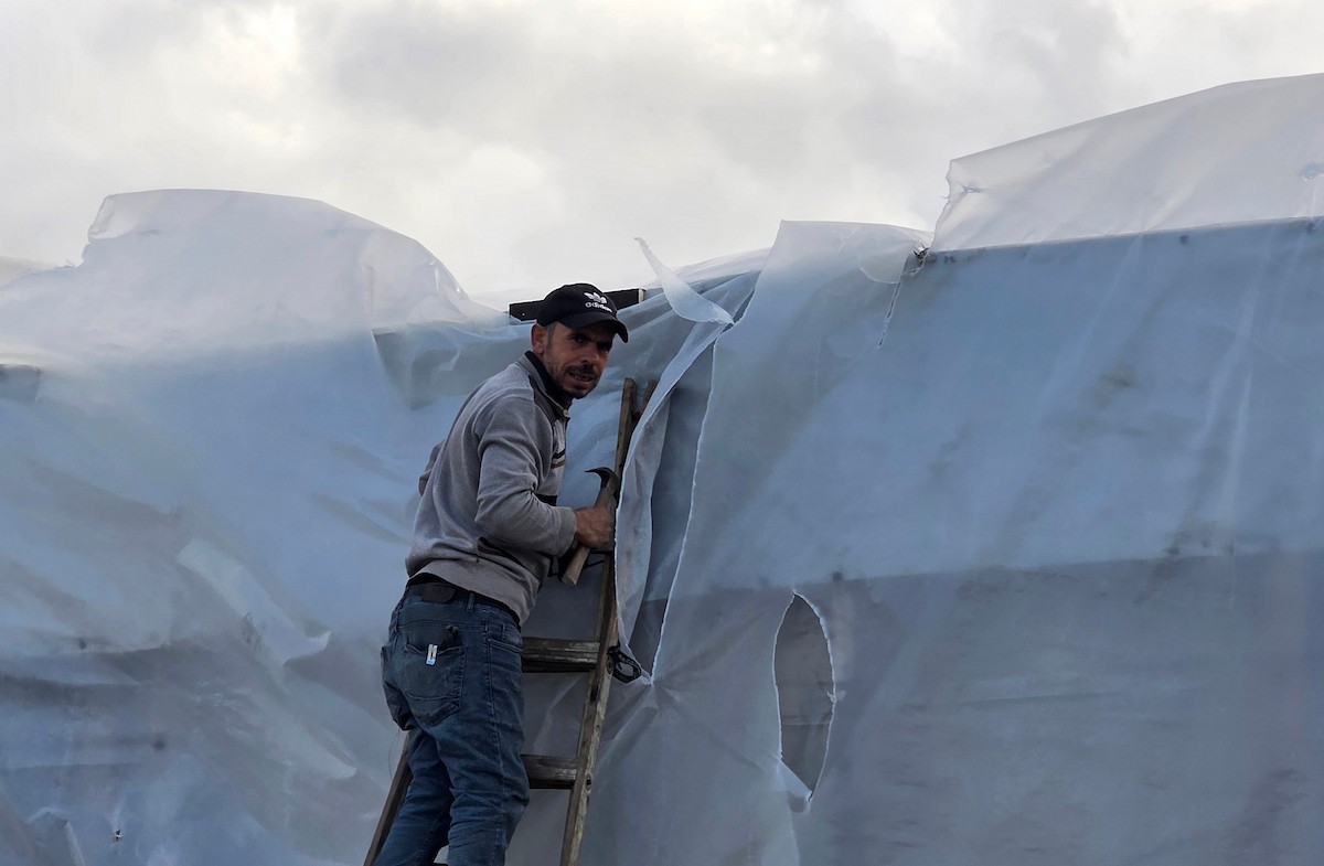 يُكافح الفلسطينيون النازحون، المقيمون في خيام مؤقتة، من أجل البقاء في ظل ظروف قاسية، حيث تجتاح الأمطار والعواصف الشديدة منطقة المواصي، غرب خان يونس، جنوب قطاع غزة، في 28 ديسمبر/كانون الأول 2025. (صورة: طارق محمد)