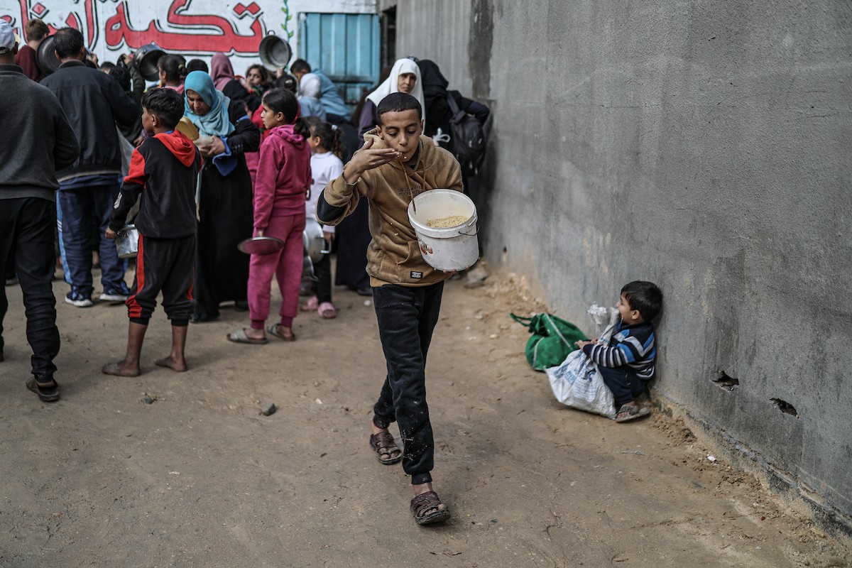يصطفّ فلسطينيون لتلقّي الطعام من مطبخ خيري في تجمع للنازحين بمخيم النصيرات للاجئين، وسط قطاع غزة. ١٧ ديسمبر/كانون الأول ٢٠٢٥. تصوير: رمزي أبو عامر / (apa)