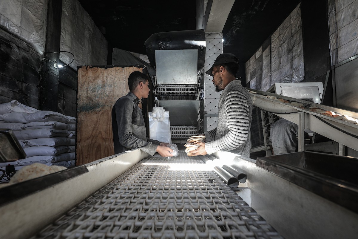 عمال فلسطينيون يعيدون تشغيل أحد أقدم المخابز في مخيم النصيرات للاجئين بعد إغلاقه لمدة عامين بسبب الحرب (20).jpg