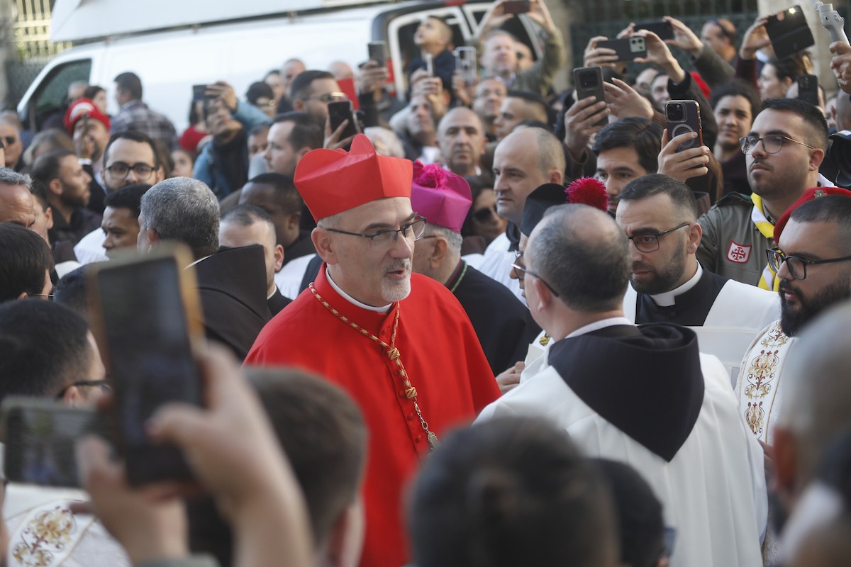 البطريرك اللاتيني للقدس، الكاردينال الإيطالي بييرباتيستا بيتسابالا يستقبل الحجاج والسياح لدى وصوله لترؤس قداس منتصف الليل في كنيسة المهد بمدينة بيت لحم، 24 ديسمبر/كانون الأول 2025،  (صور: مأمون وزواز/ apa)