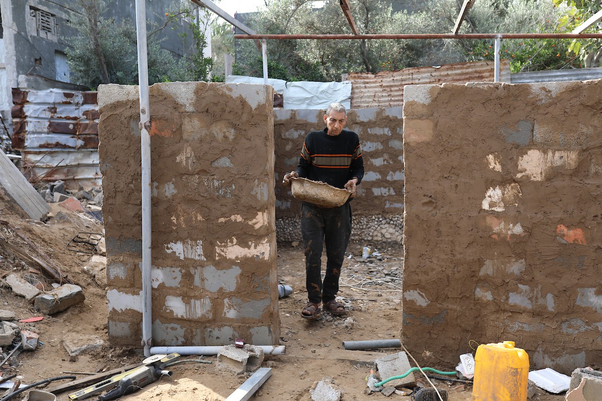 الفلسطيني أحمد المبحوح، مريض سرطان، يبني منزلاً طينياً بيديه في مخيم البريج للاجئين وسط قطاع غزة، 15 ديسمبر/كانون الأول 2025. عدسة: رمزي أبو عامر