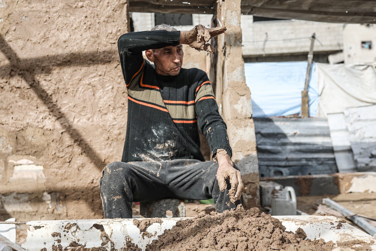 الفلسطيني أحمد المبحوح، مريض سرطان، يبني منزلاً طينياً بيديه في مخيم البريج للاجئين وسط قطاع غزة، 15 ديسمبر/كانون الأول 2025. عدسة: رمزي أبو عامر