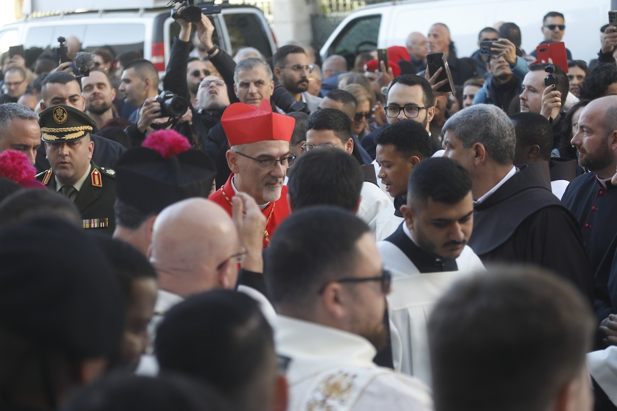 البطريرك اللاتيني للقدس، الكاردينال الإيطالي بييرباتيستا بيتسابالا يستقبل الحجاج والسياح لدى وصوله لترؤس قداس منتصف الليل في كنيسة المهد بمدينة بيت لحم، 24 ديسمبر/كانون الأول 2025،  (صور: مأمون وزواز/ apa)