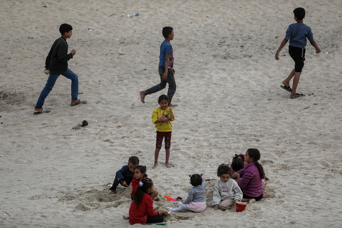 يقضي فلسطينيون نازحون وقتًا على الشاطئ مقابل خيامهم الممتدة على طول ميناء غزة، في غزة، 5 ديسمبر/كانون الأول 2025. تصوير: عمر أشتوي