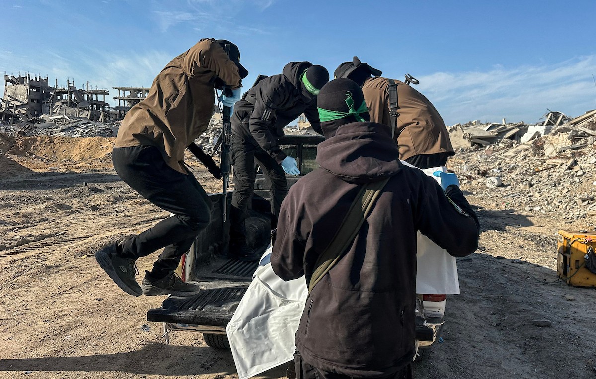 مسلحون من حماس والجهاد الإسلامي في فلسطين يسلمون لأفراد الصليب الأحمر جثة استعادوها من بيت لاهيا قبل تسليمها لإسرائيل لتحديد ما إذا كانت تعود لأحد الرهائن، شمال قطاع غزة، 3 ديسمبر/كانون الأول 2025