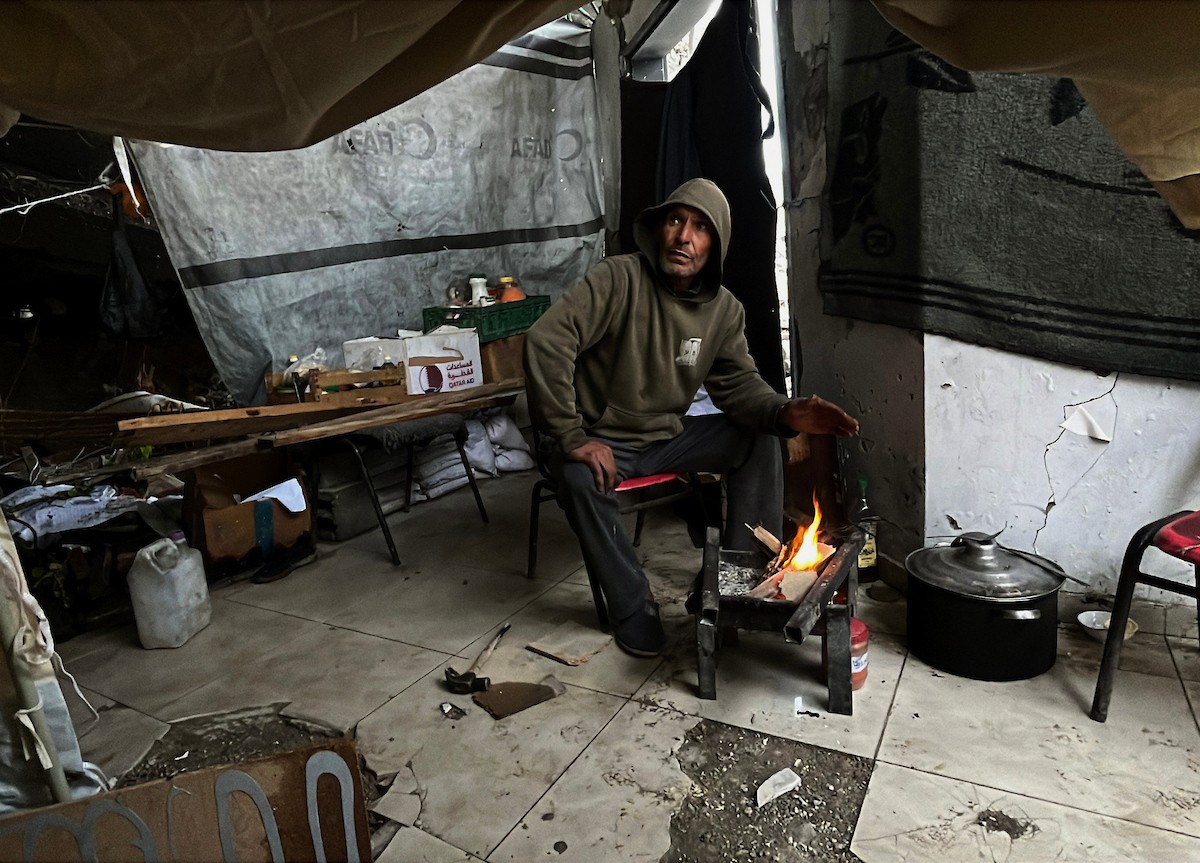 يعيش أشرف وشادية السرساوي مع أحفادهما العشرة داخل خيمة مؤقتة نُصبت في مبنى غير آمن إنشائياً غرب مدينة غزة، وسط تدهور الأوضاع الإنسانية.18 ديسمبر/كانون الأول 2025. صورة: مطر الزاق