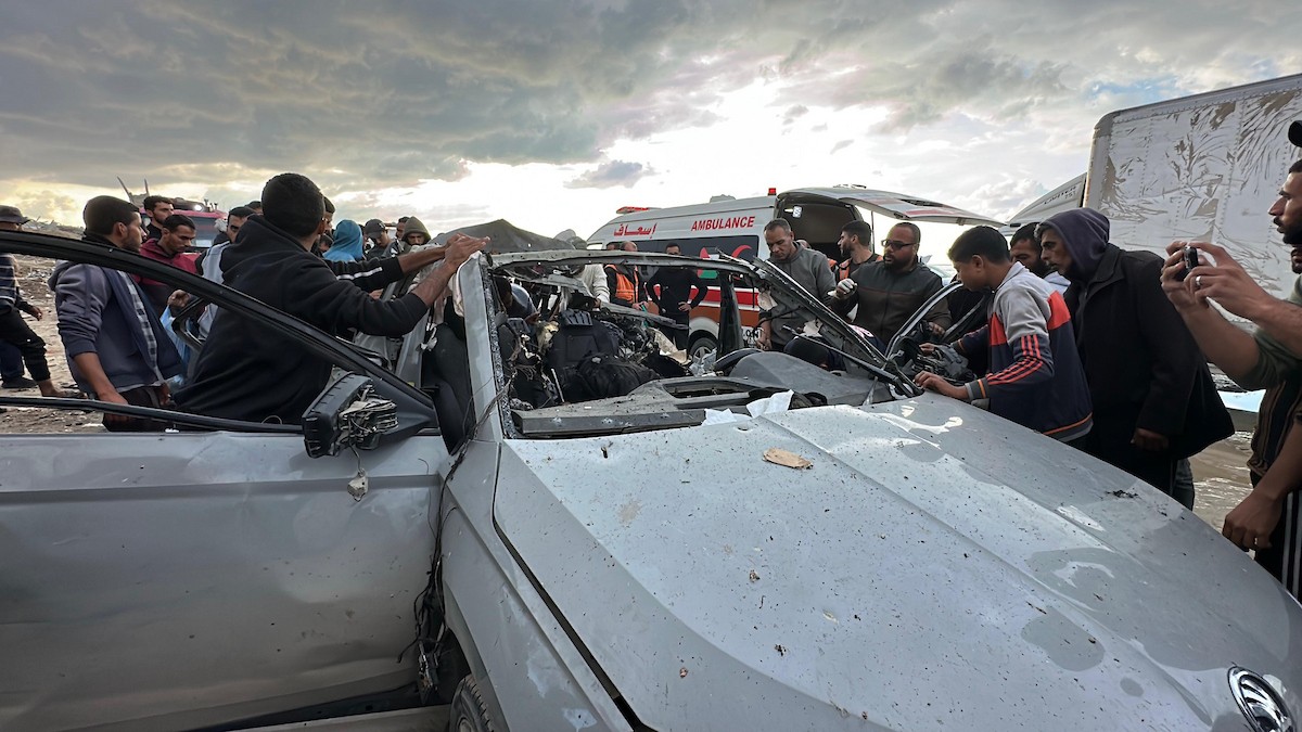 فلسطينيون يتفقدون موقع غارة إسرائيلية استهدفت سيارة على شارع لرشيد غرب مدينة غزة، 13 ديسمبر/كانون الأول 2025. صور: عمر أشتوي