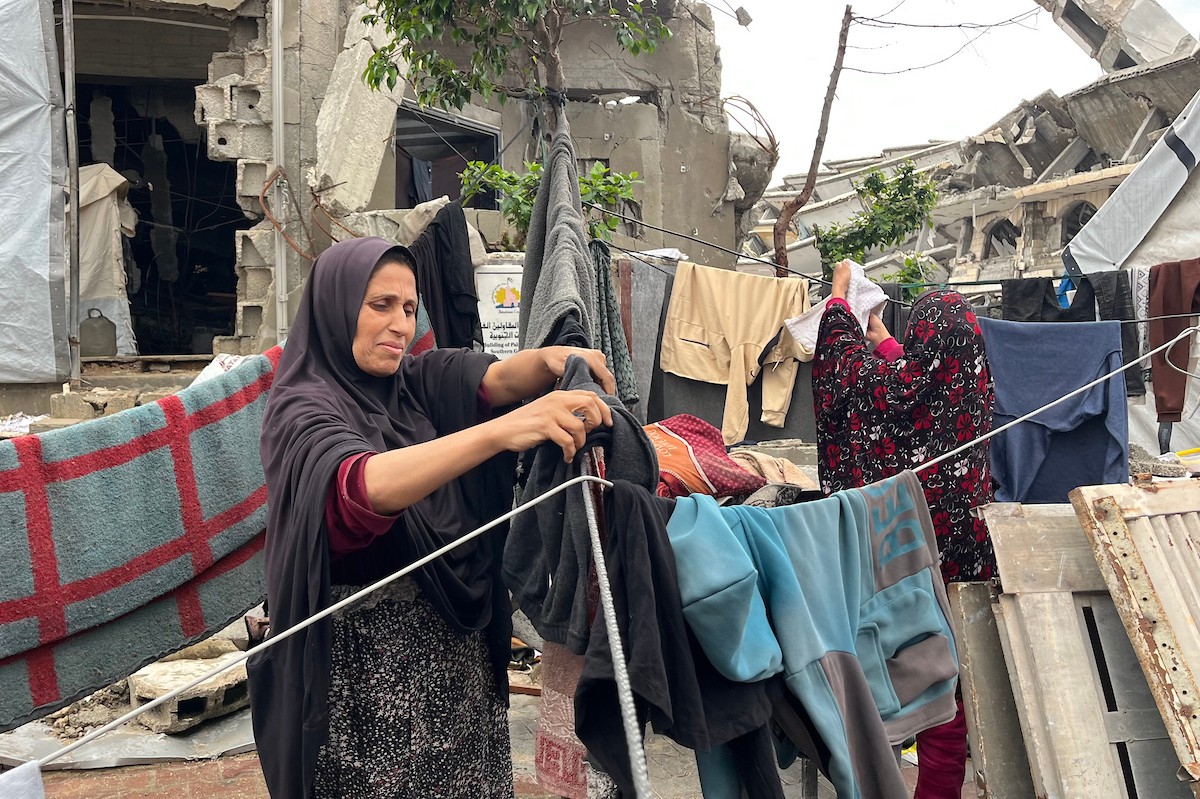 يعيش أشرف وشادية السرساوي مع أحفادهما العشرة داخل خيمة مؤقتة نُصبت في مبنى غير آمن إنشائياً غرب مدينة غزة، وسط تدهور الأوضاع الإنسانية.18 ديسمبر/كانون الأول 2025. صورة: مطر الزاق