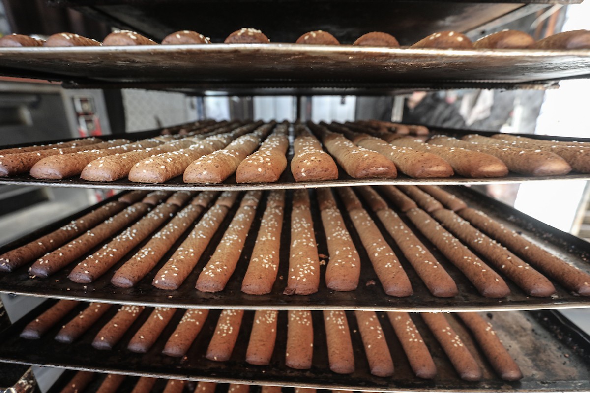 عمال فلسطينيون يعيدون تشغيل أحد أقدم المخابز في مخيم النصيرات للاجئين بعد إغلاقه لمدة عامين بسبب الحرب (26).jpg