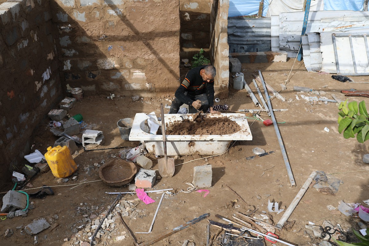الفلسطيني أحمد المبحوح، مريض سرطان، يبني منزلاً طينياً بيديه في مخيم البريج للاجئين وسط قطاع غزة، 15 ديسمبر/كانون الأول 2025. عدسة: رمزي أبو عامر