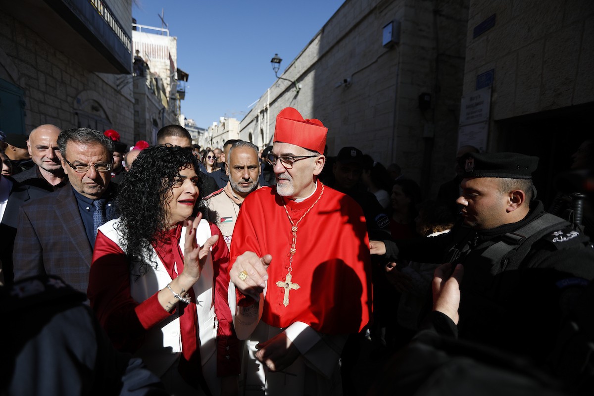البطريرك اللاتيني للقدس، الكاردينال الإيطالي بييرباتيستا بيتسابالا يستقبل الحجاج والسياح لدى وصوله لترؤس قداس منتصف الليل في كنيسة المهد بمدينة بيت لحم، 24 ديسمبر/كانون الأول 2025،  (صور: مأمون وزواز/ apa)