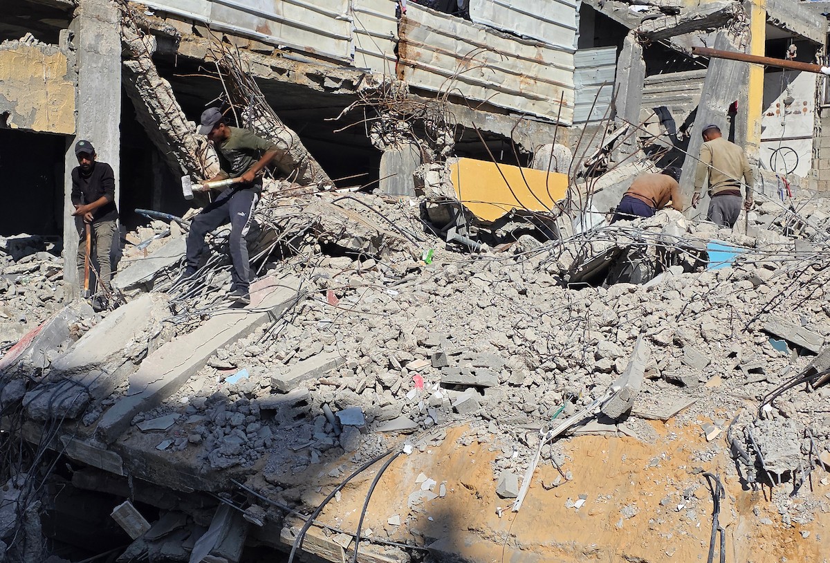 في خان يونس، جنوب قطاع غزة، يقوم أصحاب المتاجر الفلسطينيون بإزالة الأنقاض بأيديهم، ويعيدون بناء متاجرهم المتضررة باستخدام الحجارة والطين الأحمر، 27 ديسمبر/كانون الأول 2025 (صورة: طارق محمد)