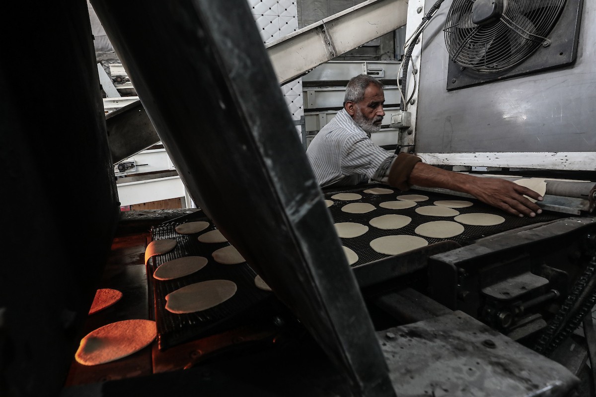 عمال فلسطينيون يعيدون تشغيل أحد أقدم المخابز في مخيم النصيرات للاجئين بعد إغلاقه لمدة عامين بسبب الحرب (32).jpg