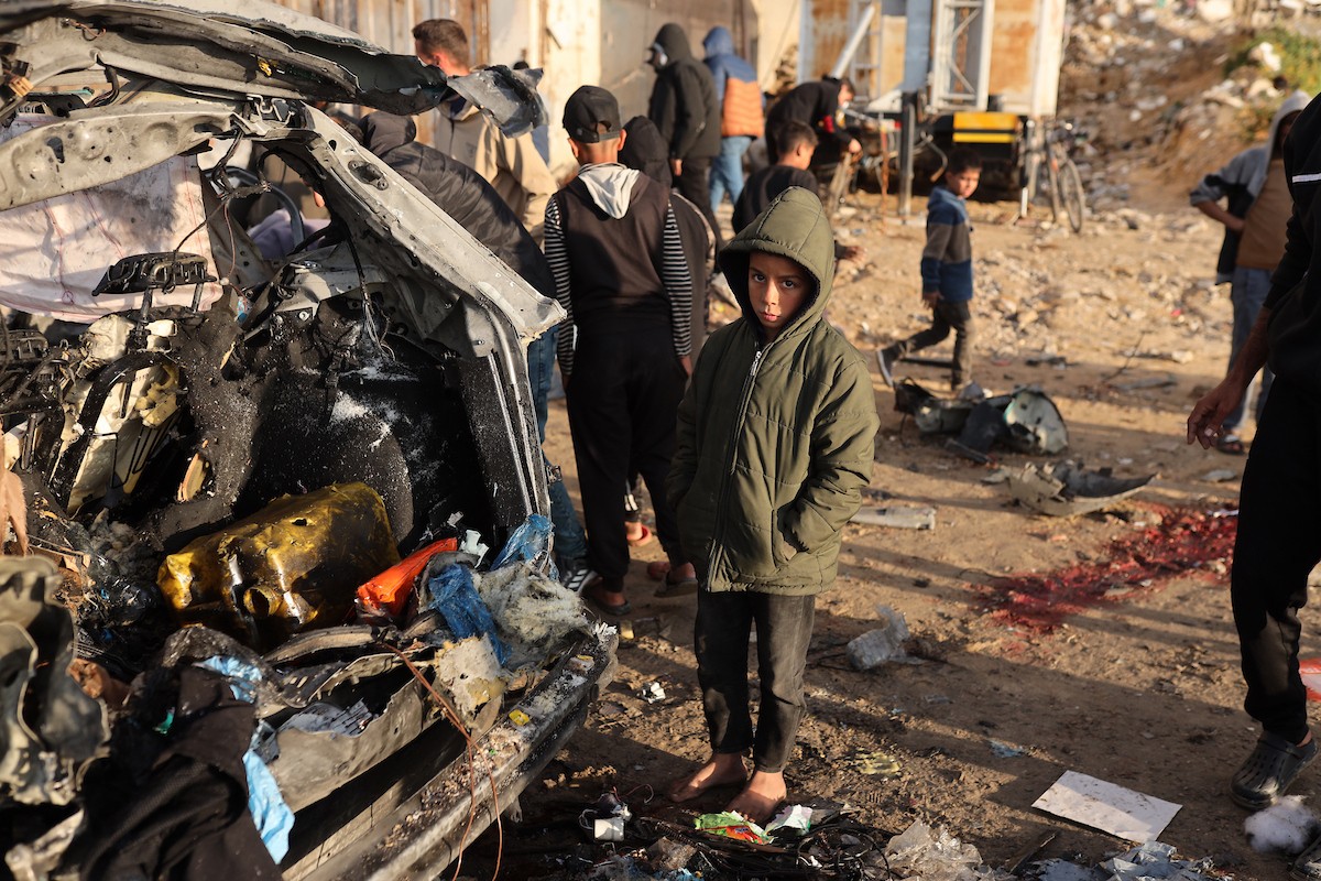 فلسطينيون يتفقدون موقع غارة إسرائيلية استهدفت سيارة على شارع لرشيد غرب مدينة غزة، 13 ديسمبر/كانون الأول 2025. صور: عمر أشتوي