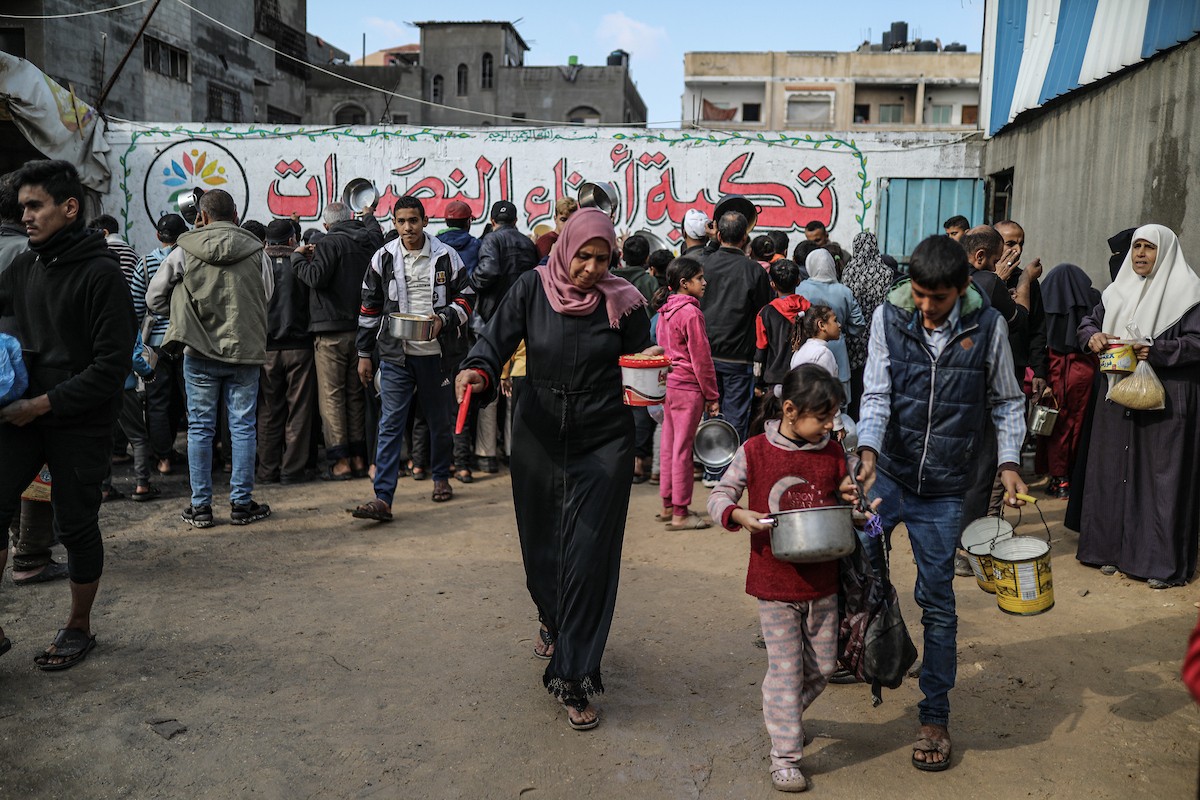 يصطفّ فلسطينيون لتلقّي الطعام من مطبخ خيري في تجمع للنازحين بمخيم النصيرات للاجئين، وسط قطاع غزة. ١٧ ديسمبر/كانون الأول ٢٠٢٥. تصوير: رمزي أبو عامر / (apa)
