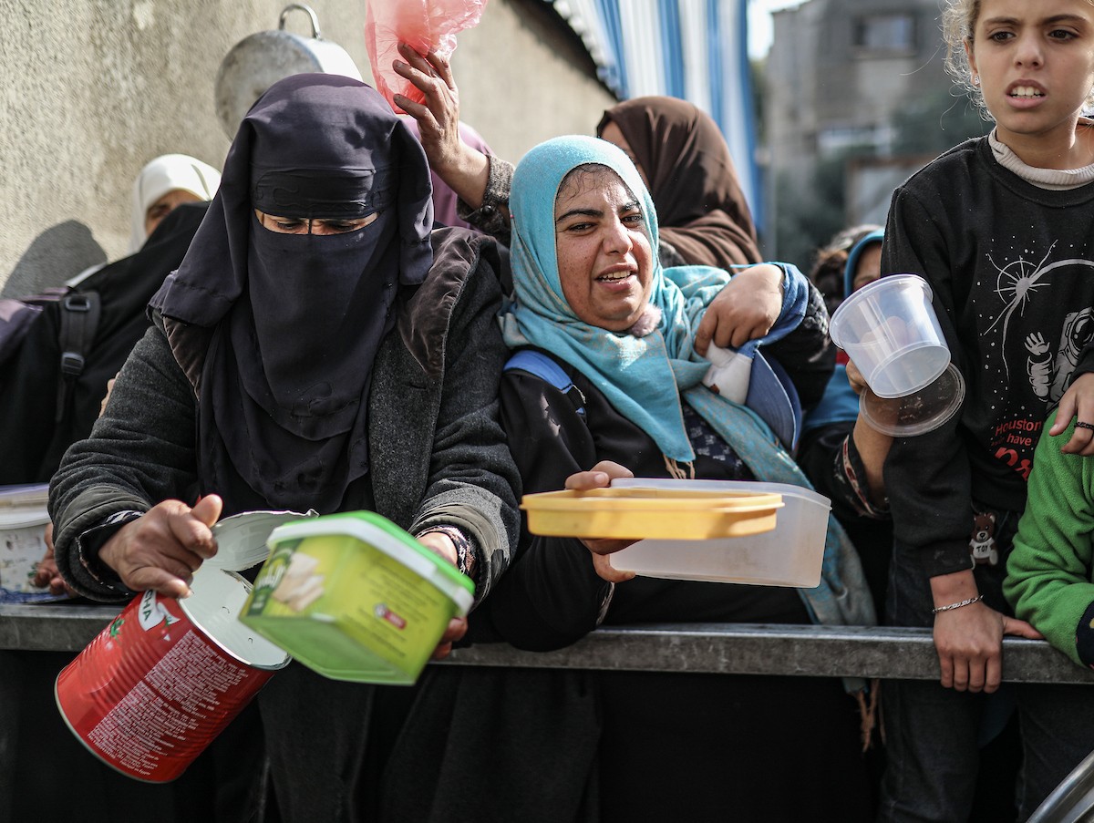 يصطفّ فلسطينيون لتلقّي الطعام من مطبخ خيري في تجمع للنازحين بمخيم النصيرات للاجئين، وسط قطاع غزة. ١٧ ديسمبر/كانون الأول ٢٠٢٥. تصوير: رمزي أبو عامر / (apa)