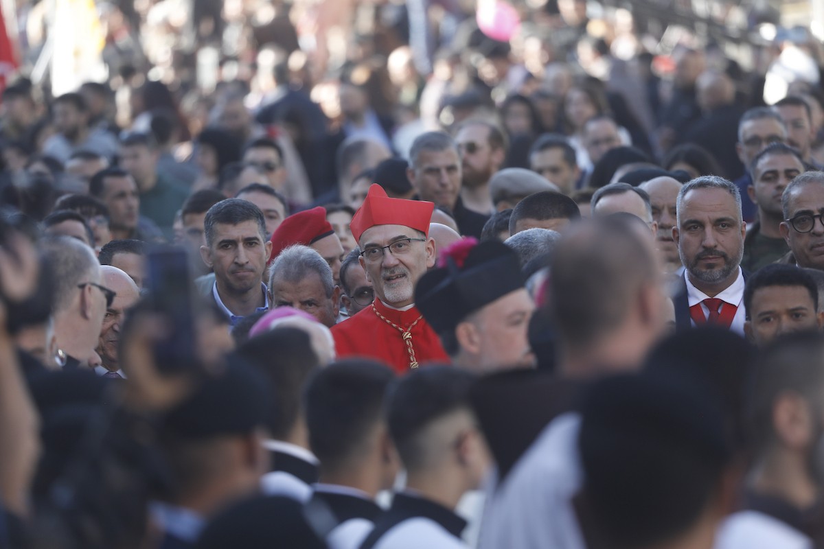 البطريرك اللاتيني للقدس، الكاردينال الإيطالي بييرباتيستا بيتسابالا يستقبل الحجاج والسياح لدى وصوله لترؤس قداس منتصف الليل في كنيسة المهد بمدينة بيت لحم، 24 ديسمبر/كانون الأول 2025،  (صور: مأمون وزواز/ apa)