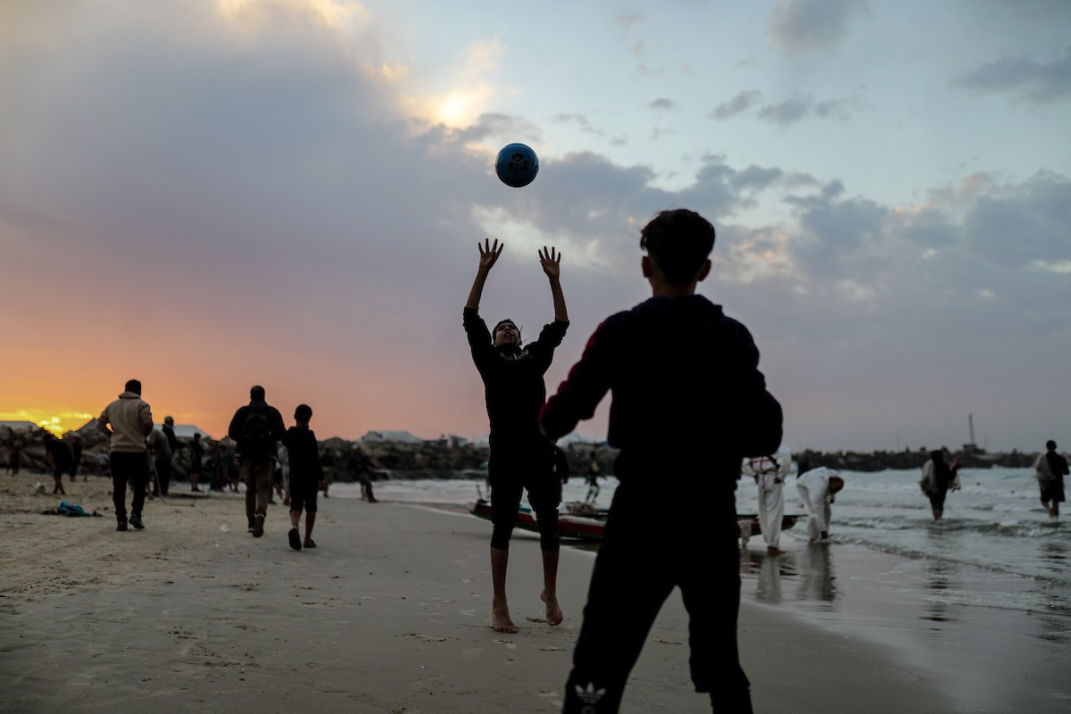 يقضي فلسطينيون نازحون وقتًا على الشاطئ مقابل خيامهم الممتدة على طول ميناء غزة، في غزة، 5 ديسمبر/كانون الأول 2025. تصوير: عمر أشتوي