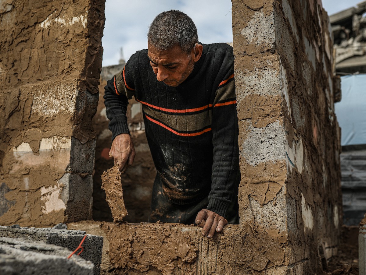الفلسطيني أحمد المبحوح، مريض سرطان، يبني منزلاً طينياً بيديه في مخيم البريج للاجئين وسط قطاع غزة، 15 ديسمبر/كانون الأول 2025. عدسة: رمزي أبو عامر