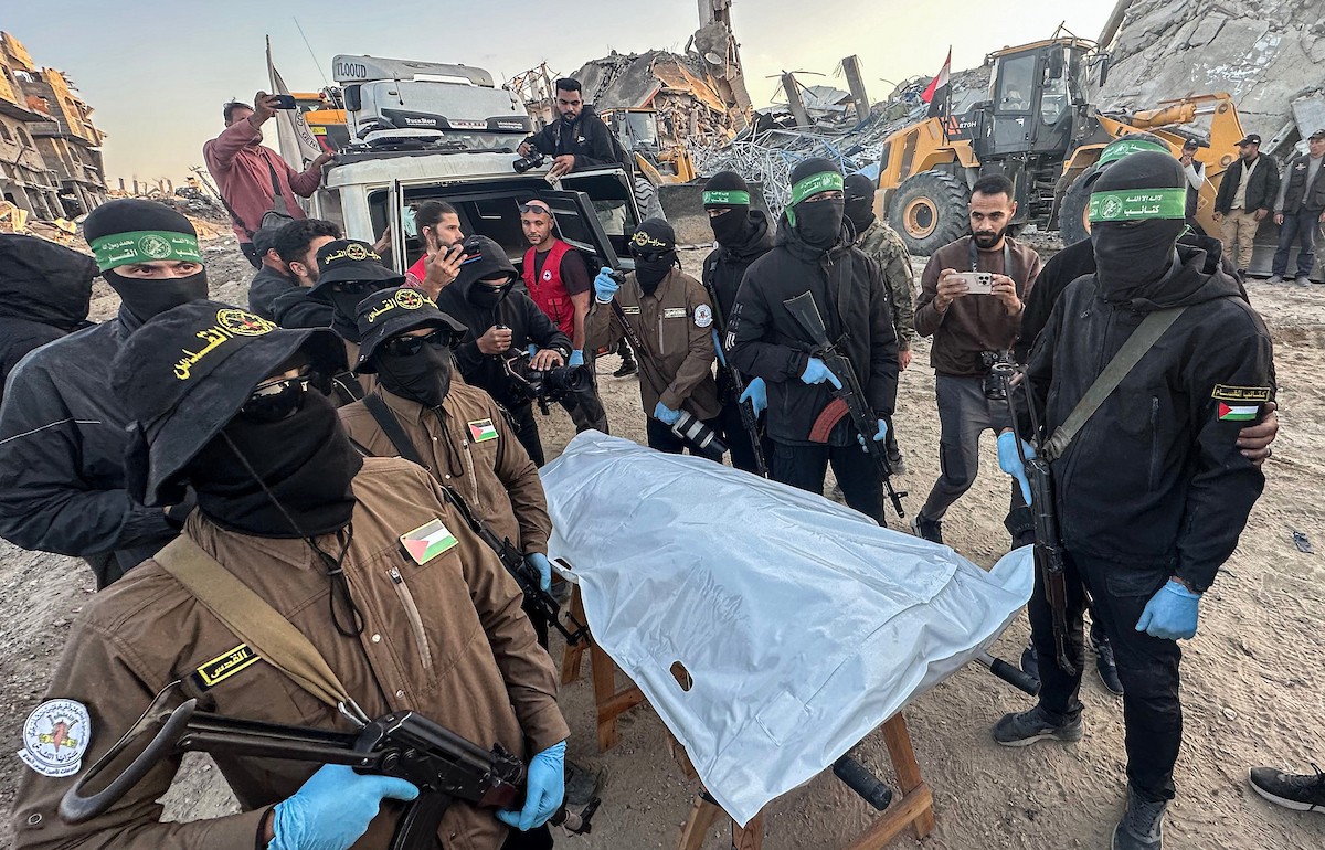 مسلحون من حماس والجهاد الإسلامي في فلسطين يسلمون لأفراد الصليب الأحمر جثة استعادوها من بيت لاهيا قبل تسليمها لإسرائيل لتحديد ما إذا كانت تعود لأحد الرهائن، شمال قطاع غزة، 3 ديسمبر/كانون الأول 2025