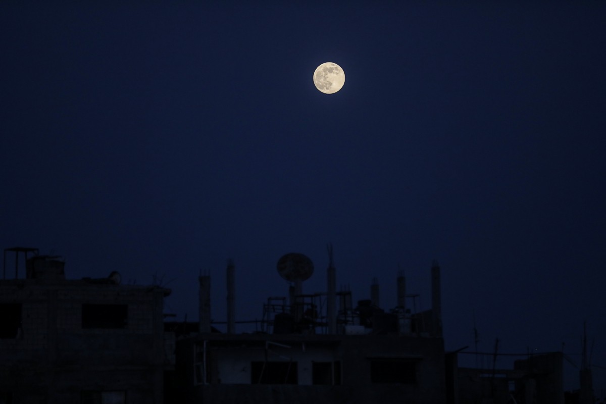 القمر البارد للغاية، آخر قمر عملاق لعام 2025، يظهر فوق سماء مدينة غزة، 4 ديسمبر/كانون الأول 2025. تصوير: عمر أشتوي