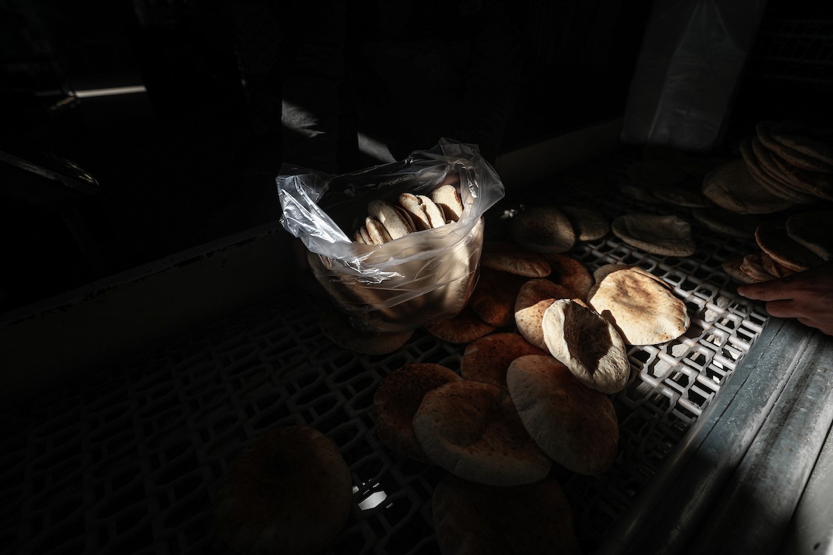 عمال فلسطينيون يعيدون تشغيل أحد أقدم المخابز في مخيم النصيرات للاجئين بعد إغلاقه لمدة عامين بسبب الحرب (17).jpg