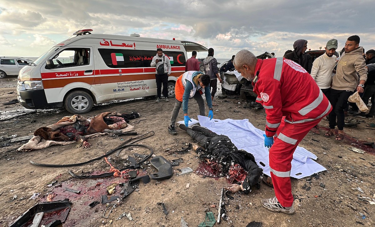 فلسطينيون يتفقدون موقع غارة إسرائيلية استهدفت سيارة على شارع لرشيد غرب مدينة غزة، 13 ديسمبر/كانون الأول 2025. صور: عمر أشتوي