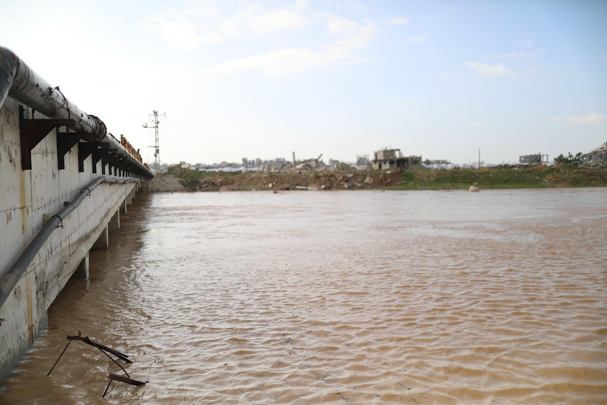 فتح الجيش الإسرائيلي مجرى وادي غزة، مما أدى إلى ارتفاع منسوب المياه إلى مستوى الجسر. وقد فاقم هذا الوضع معاناة العائلات النازحة التي كانت تقيم في خيام بالمنطقة بعد أن فاض الوادي وجرف خيامها، 29 ديسمبر/كانون الأول 2025. صورة: رمزي أبو عامر