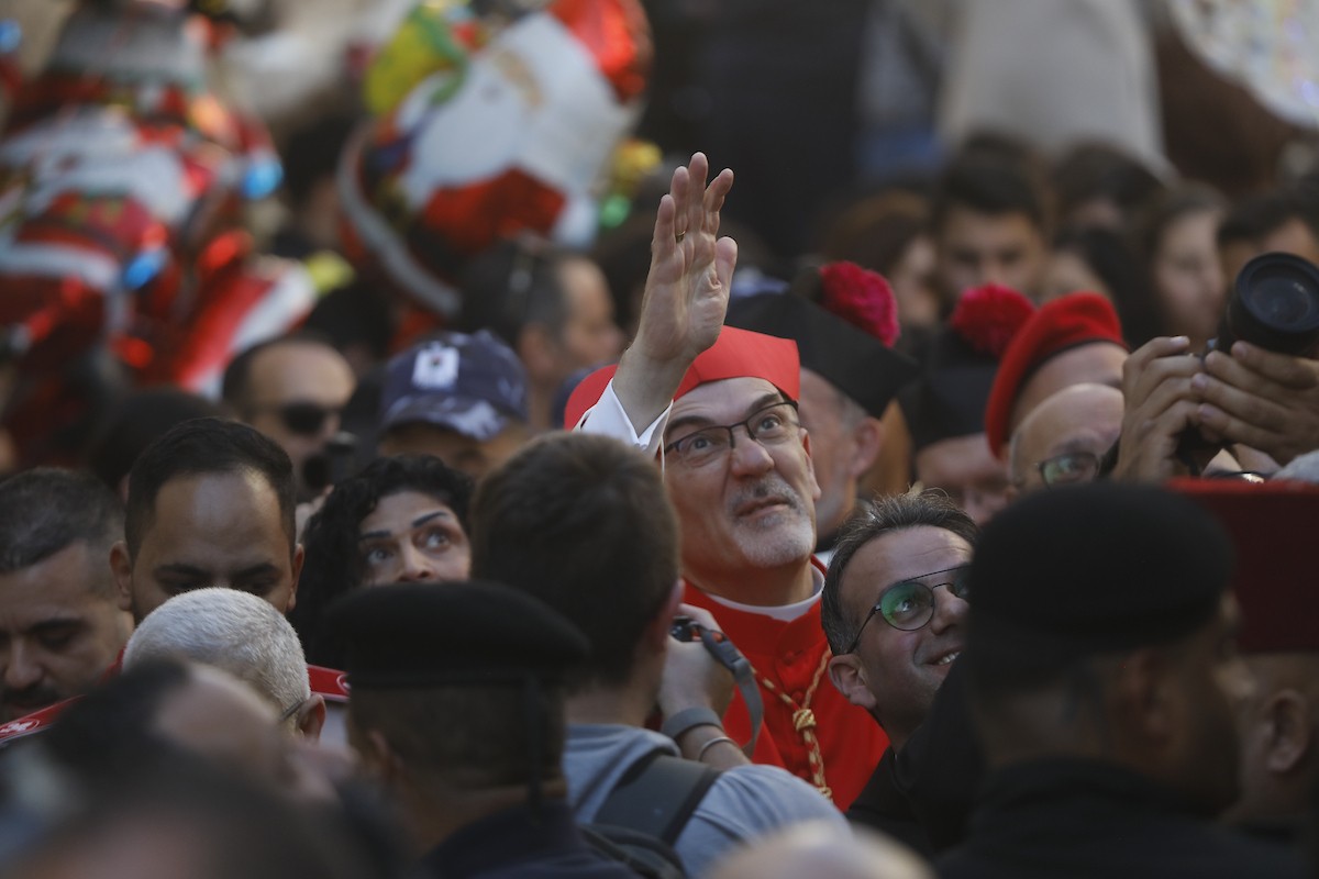 البطريرك اللاتيني للقدس، الكاردينال الإيطالي بييرباتيستا بيتسابالا يستقبل الحجاج والسياح لدى وصوله لترؤس قداس منتصف الليل في كنيسة المهد بمدينة بيت لحم، 24 ديسمبر/كانون الأول 2025،  (صور: مأمون وزواز/ apa)