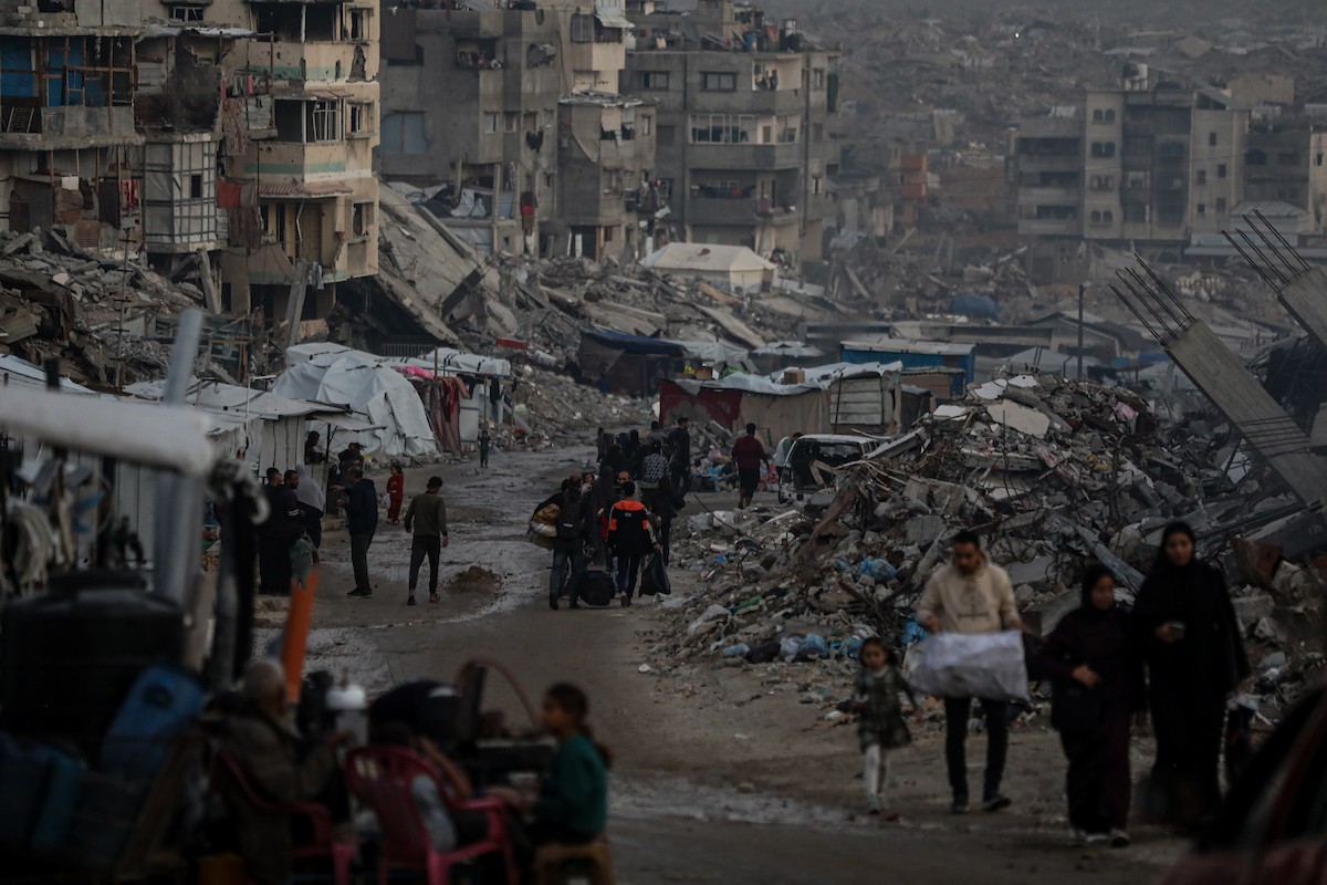 يعيش الفلسطينيون حياتهم اليومية ليلاً في خيام نصبت فوق أنقاض المباني المدمرة في حي الشيخ رضوان وسط مدينة غزة، 5 ديسمبر/كانون الأول 2025.تصوير: عمر أشتوي