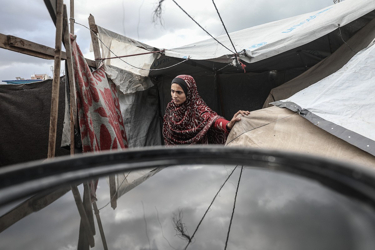 أحمد أبو ليلى أب لخمسة أطفال أصيب في الحرب  يحاول إصلاح خيمته بعد أن تضررت جراء الأمطار الغزيرة والرياح العاتية التي اجتاحت مخيم النصيرات وسط قطاع غزة، 28 ديسمبر/كانون الأول 2025.تصوير: معز صالحي