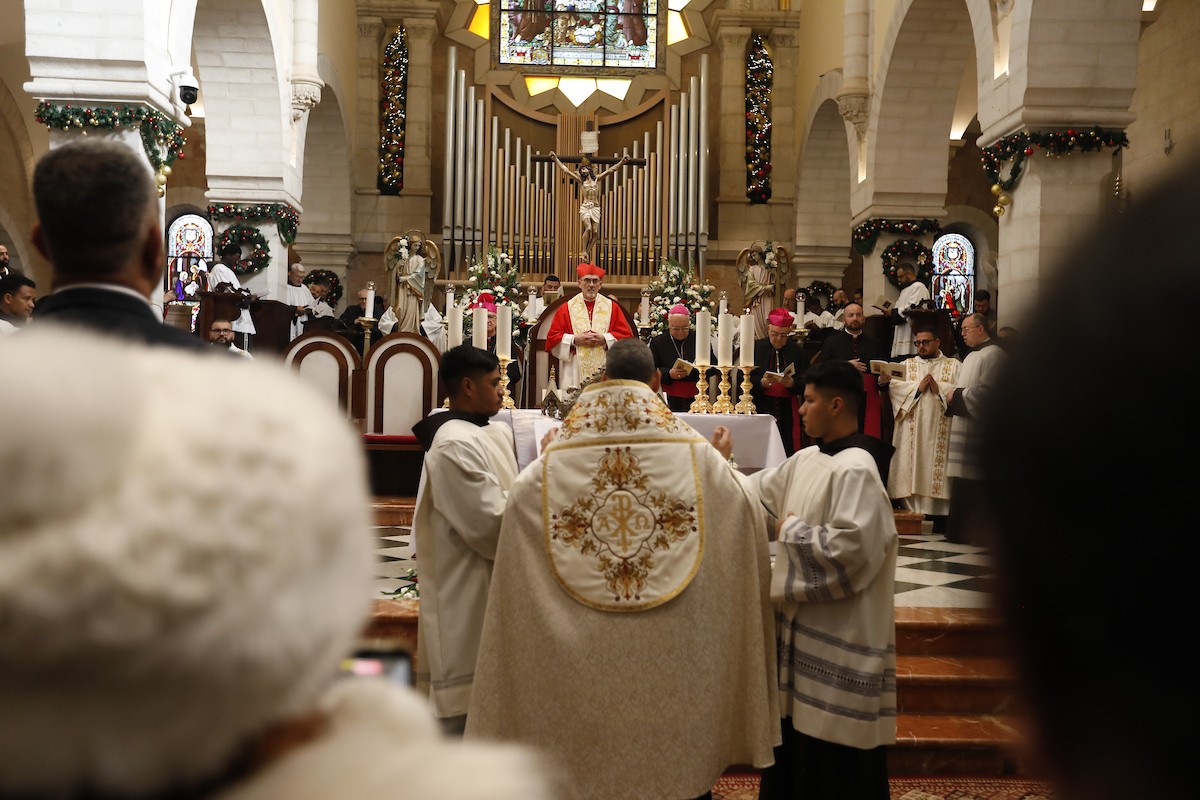 البطريرك اللاتيني للقدس، الكاردينال الإيطالي بييرباتيستا بيتسابالا يستقبل الحجاج والسياح لدى وصوله لترؤس قداس منتصف الليل في كنيسة المهد بمدينة بيت لحم، 24 ديسمبر/كانون الأول 2025،  (صور: مأمون وزواز/ apa)